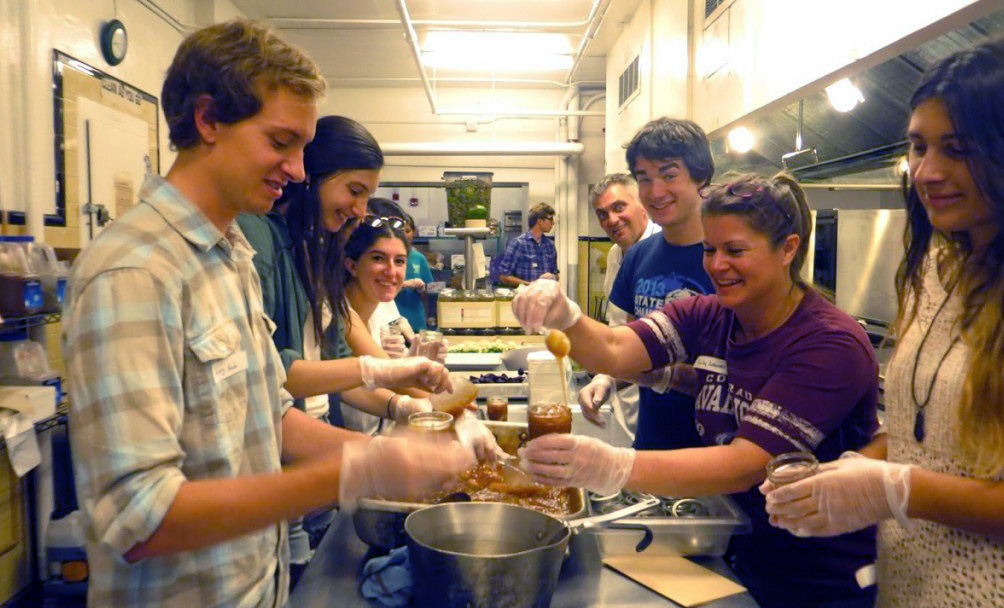 Colorado College students and staff fill their canning jars with apple preserves.