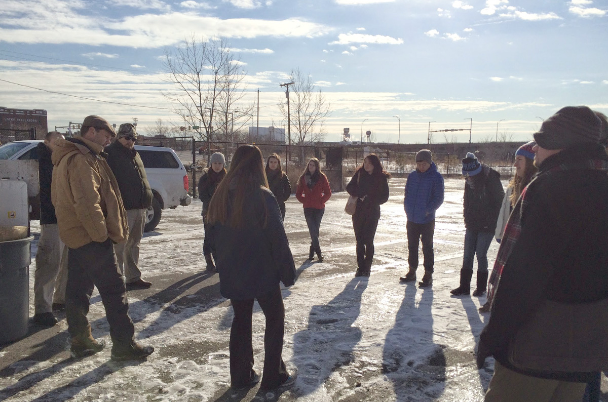 A Johns Hopkins class learning about food systems huddles up to hear from Big City Farms farmer  Rob Dunn how their greens are grown