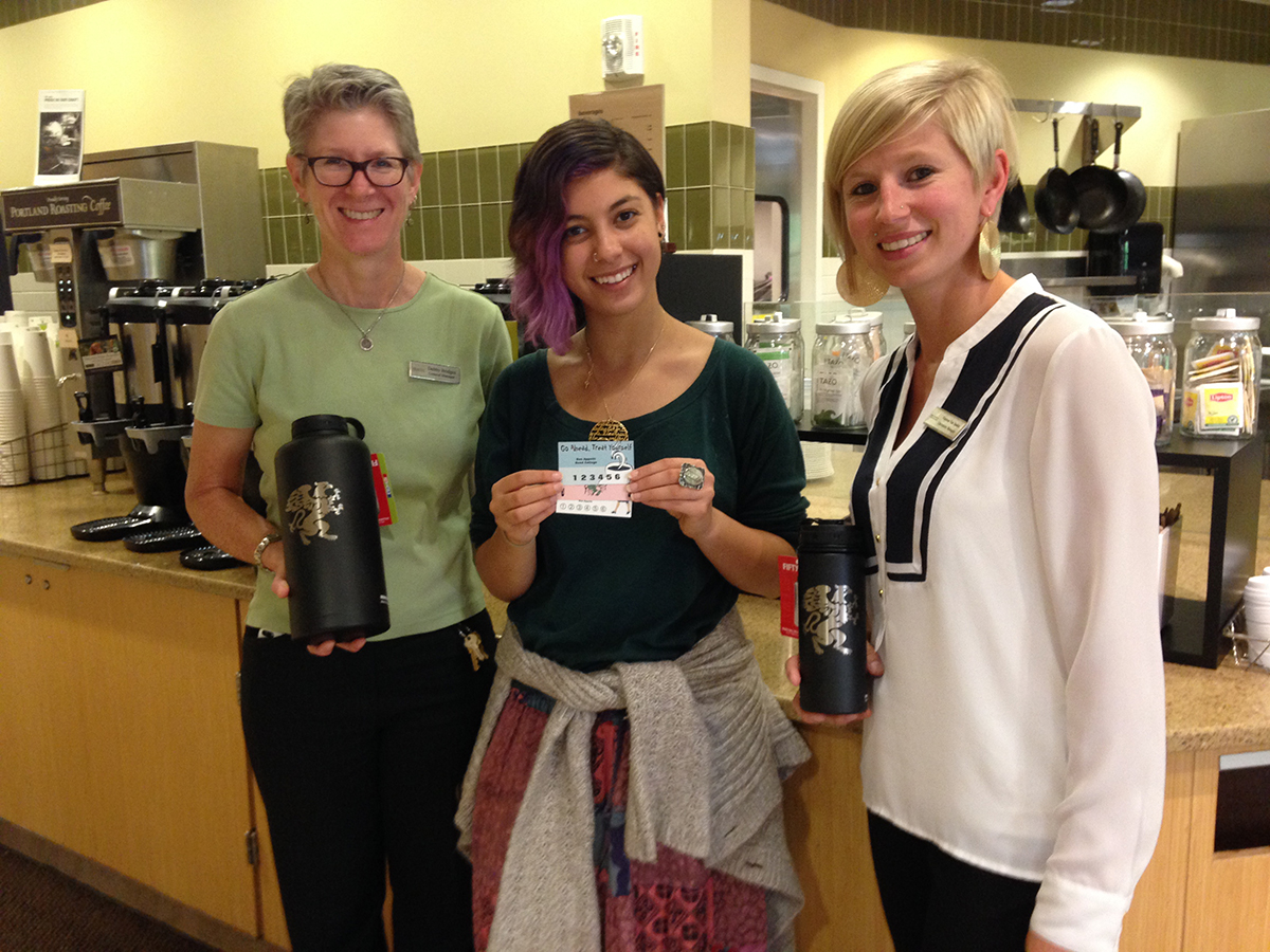 General Manager Debby Bridges, Reed Student Sustainability Coordinator Liat Kastner, and Operations Manager Vanessa van Staden pose with the reusable beverage containers and punch cards