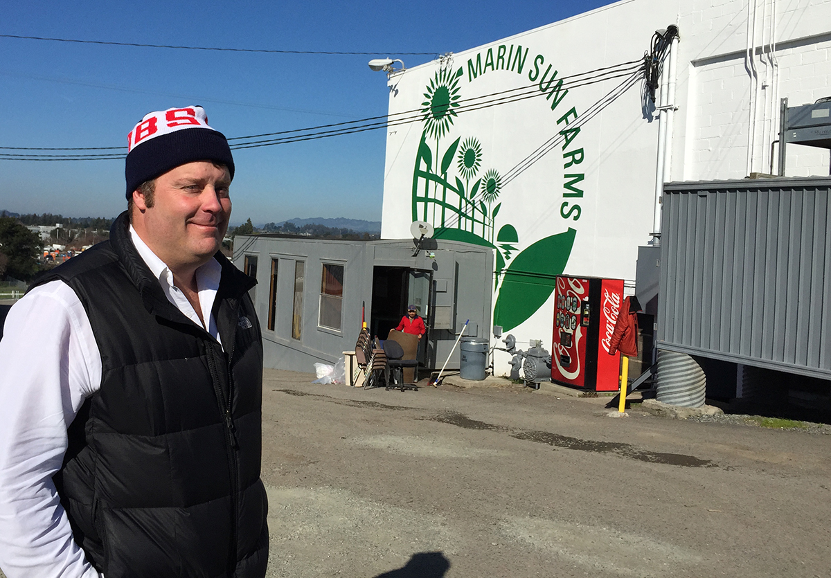 A man in a black vest stands in front of his facility in a story about Bay Area local meat producers.