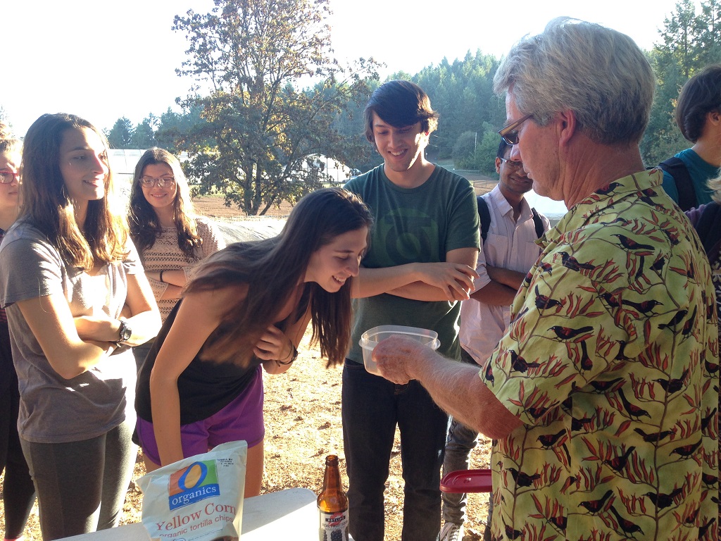 SEEDS intern Emily Merfeld smells Charlie Harris's home-made, home-grown thai chili powder.