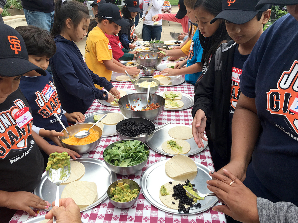 A group of Junior Giants makes tacos following a garden tour at Bon Appétit's STEM Kitchen & Garden restaurant