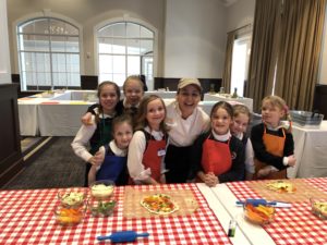 A group of students smile for the camera during their Healthy Kids in the Bon Appétit Kitchen class