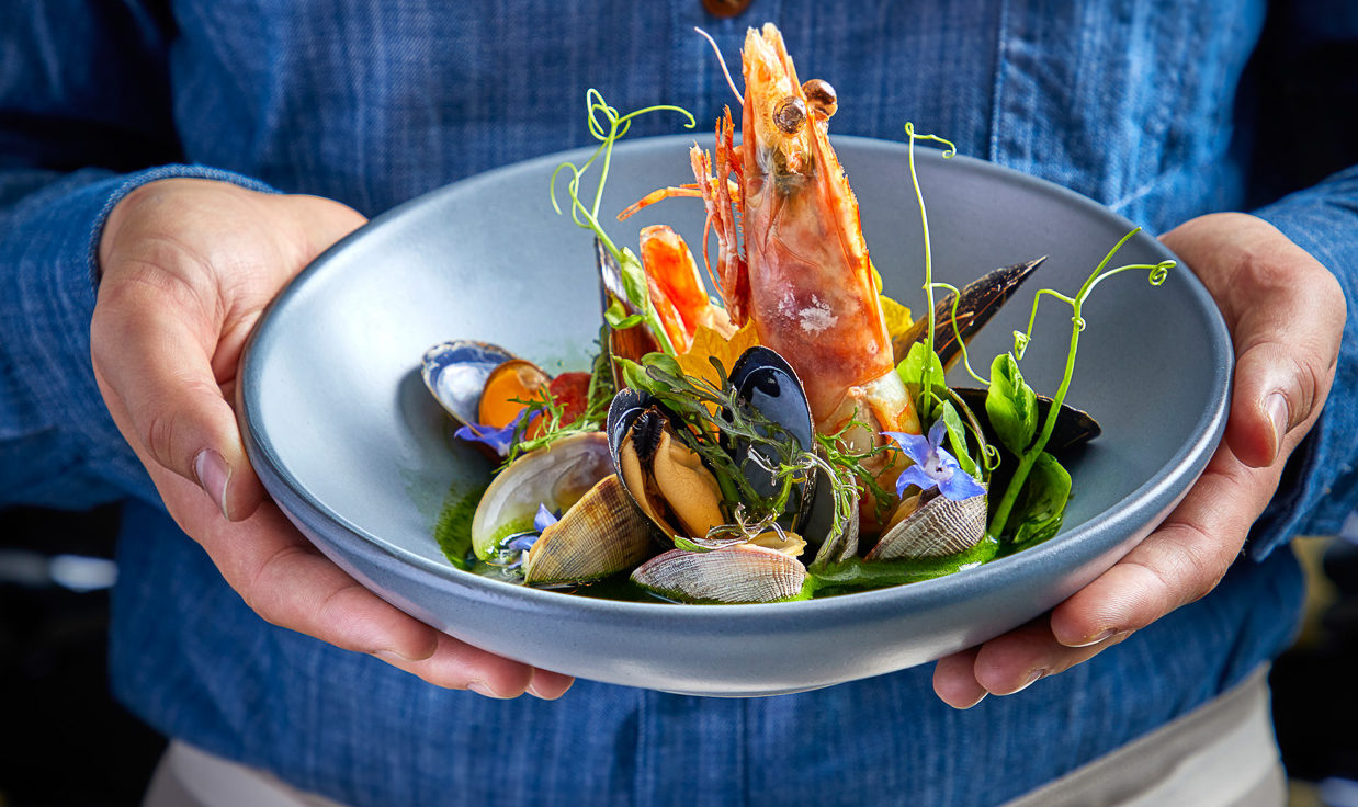 Server holding bowl of mussels