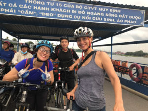Maisie and Linh on bikes aboard a ferry