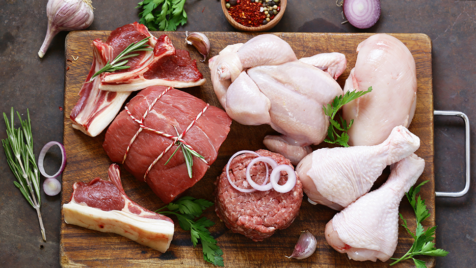 Raw meat assortment - beef, lamb, chicken on a wooden board