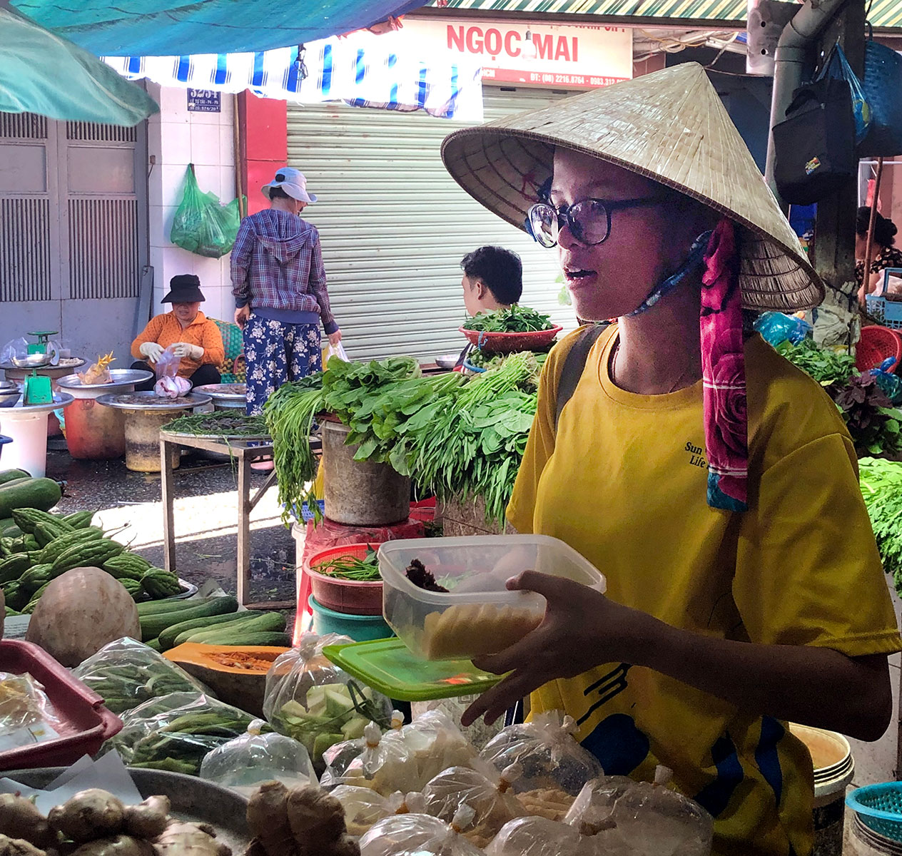 Vietnames woman holding tupperware at market