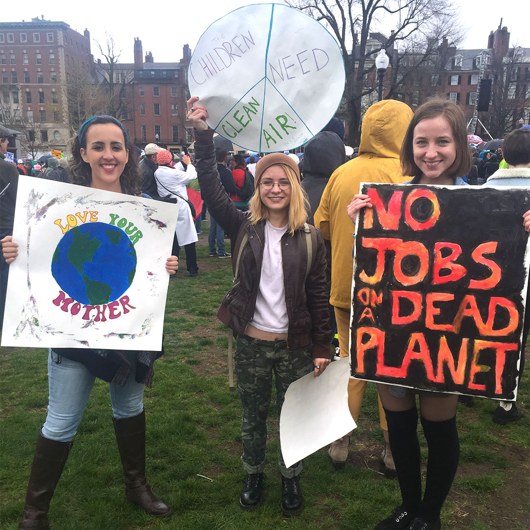 Three young women with protest signs at the 2016 March for Science
