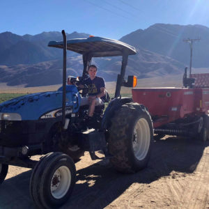 Sam driving a tractor with a hay baler