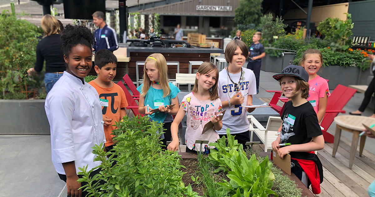 A young chef with children in a garden