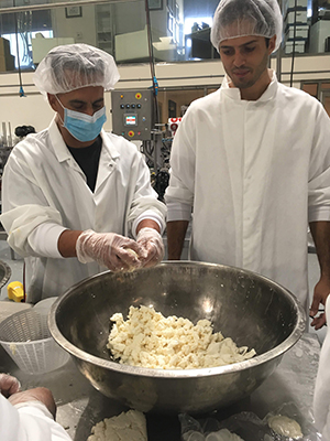 Executive Chef Justin Alarcon, left, breaks up mozzarella curds