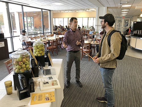 General Manager Toni Morbitt [check TK] discusses Sage Mountain produce with a student