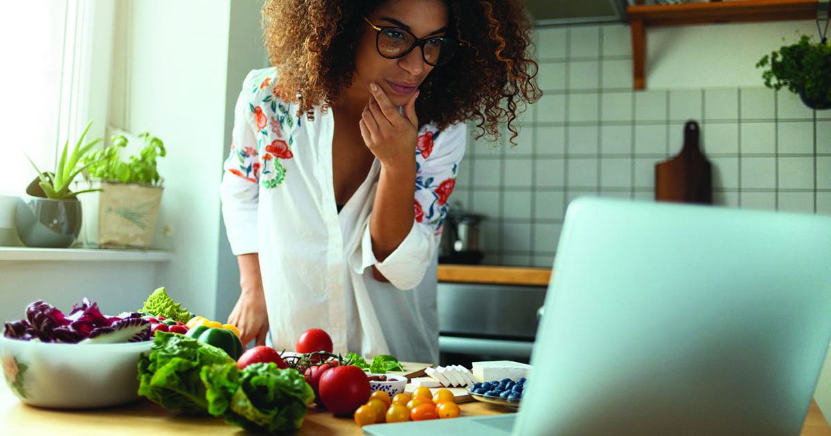 Woman in kitchen with laptop