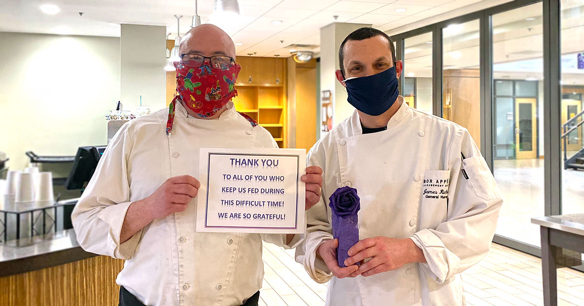 Men in masks holding award