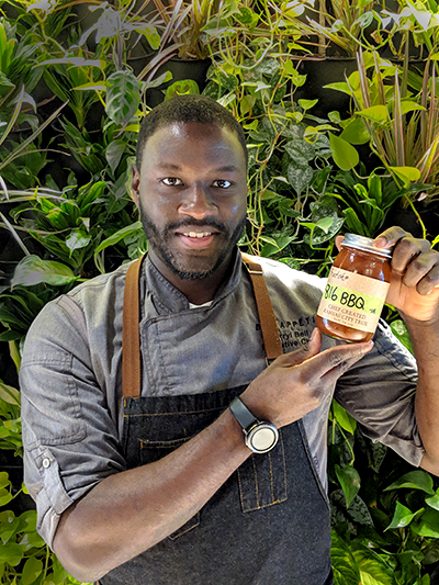 Executive Chef Darryl Bell holding a jar of 816 BBQ sauce