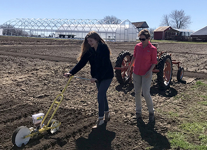 Fellow Shannon Tivona tries out the seeding machine 