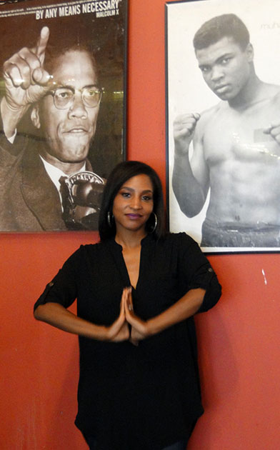 Woman in front of Malcolm X and Muhammad Ali posters