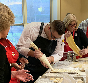 Case Western Reserve University Chef/Manager Jonathan Barger demonstrates how to pipe ricotta filling for fresh ravioli to Ronald McDonald House volunteers