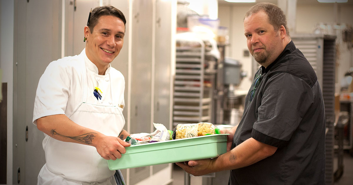 Chef handing recovered food to a Food Lifeline volunteer