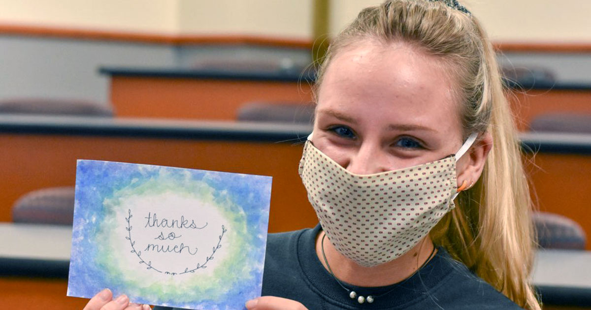 girl holding card that says thank you