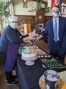 Woman hands cupcake to man in suit
