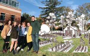 Students stand next to an etching of their proposed garden