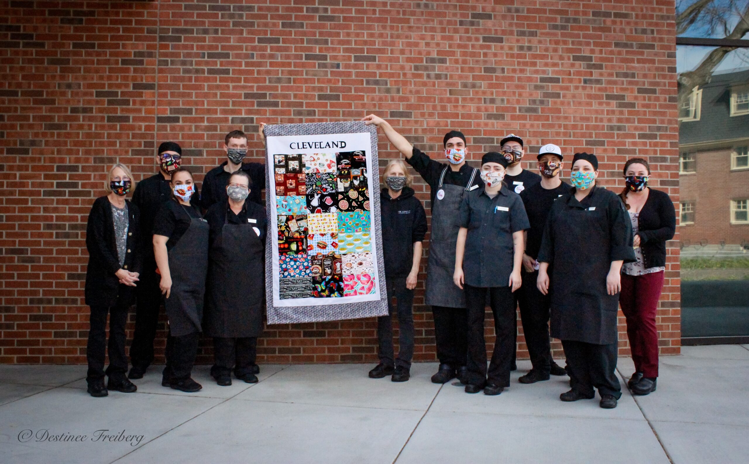 Dining services staff poses with a commemorative quillt