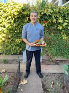 Bon Appétit at Capital Group Executive Chef Alberto Gonzalez poses with a dish he created using garden-grown produce. 