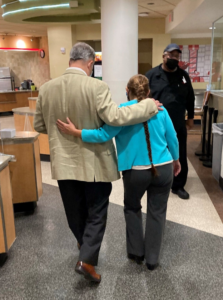Manager Yolanda Hileman hugs Mark as they walk together at a café on campus