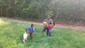 Bruce poses with his granddaughters and two of Green Valley Farms' goats.