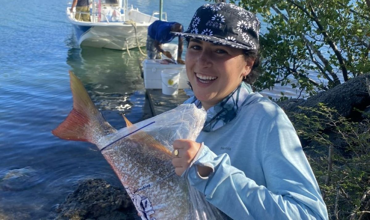 Hillary bags a fish during an ecological research trip with Colby College 