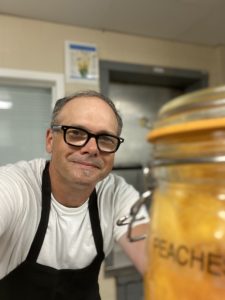 General Manager Michael Clearly poses with pickled peaches
