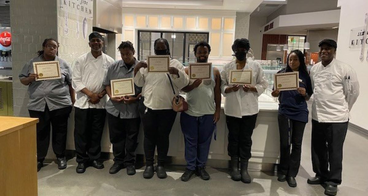 Emory Dining employees pose with their summer training completion certificates.