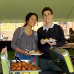Two smiling students with food in their hands