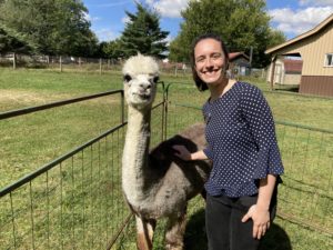 An alpaca and Midwest Fellow Elise Kulers pose together