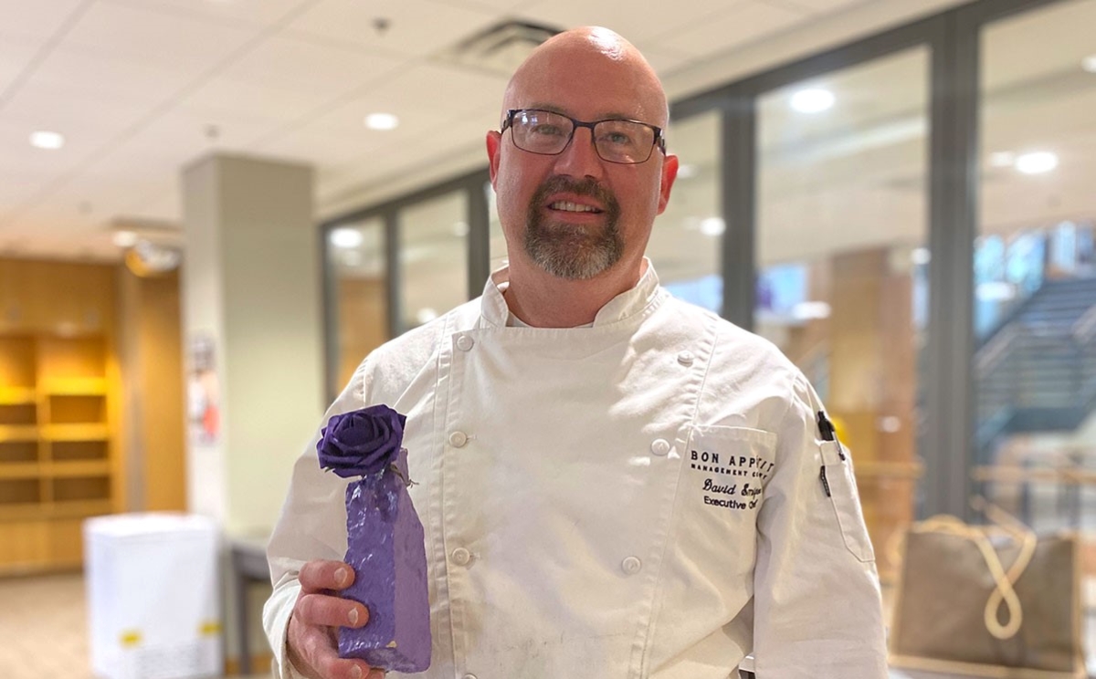 Bon Appétit at Cornell College General Manager David Smigo poses with Cornell’s Purple Rock award, which was given to the team in 2020 for their exemplary service to the campus community.
