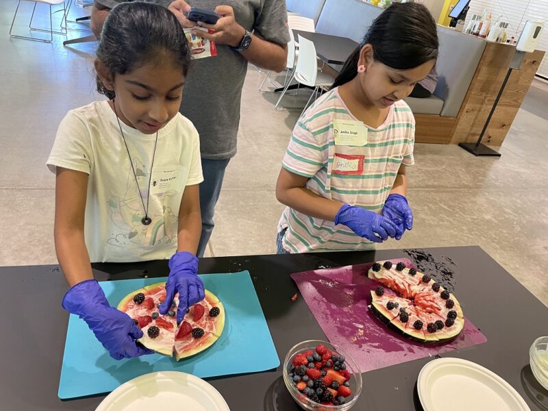 Kids make watermelon pizzas at a Bon Appetit food education event