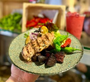 Someone holds up a plate of food to display it for a food service company's Eat Local Challenge. 