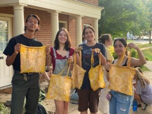 Group of people hold up yellow bags