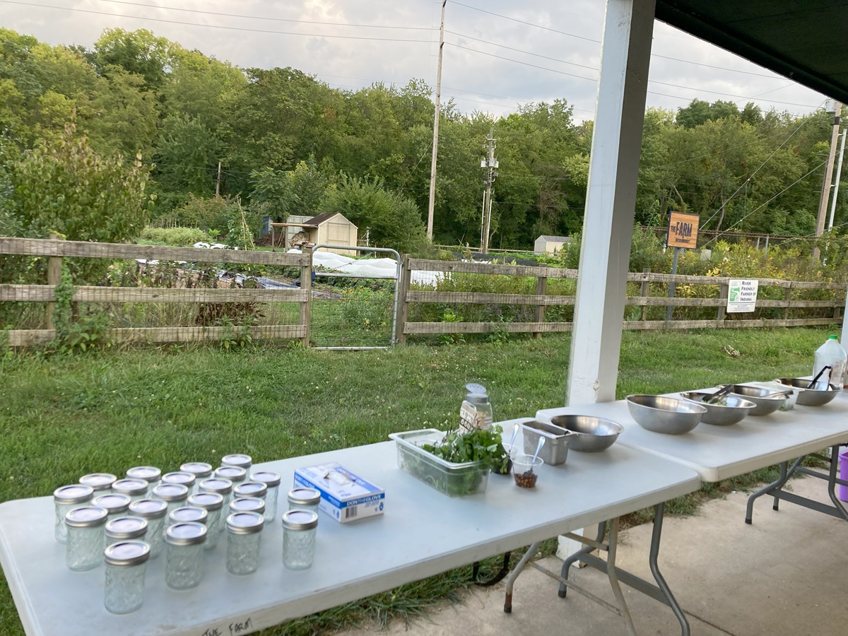 Tables set up outdoors with jars and bowls with a farm in the background.