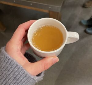 A hand holding a small cup of tea