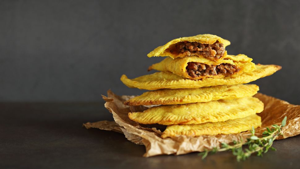 A stack of meat patties on top of a paper bag on a dark background