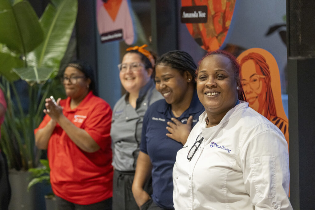 Four women smiling at a culinary event.