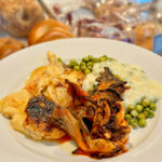 A plate of seared mushrooms and peas in a buttermilk sauce.