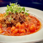 A close-up shot of a smoked pork and vegetable stew