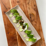 An overhead shot of a garden sushi roll on a wooden board