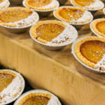 Rows of brown pies (apple butter) dusted with powdered sugar.