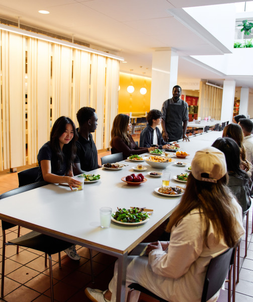 students eating and speaking with chef