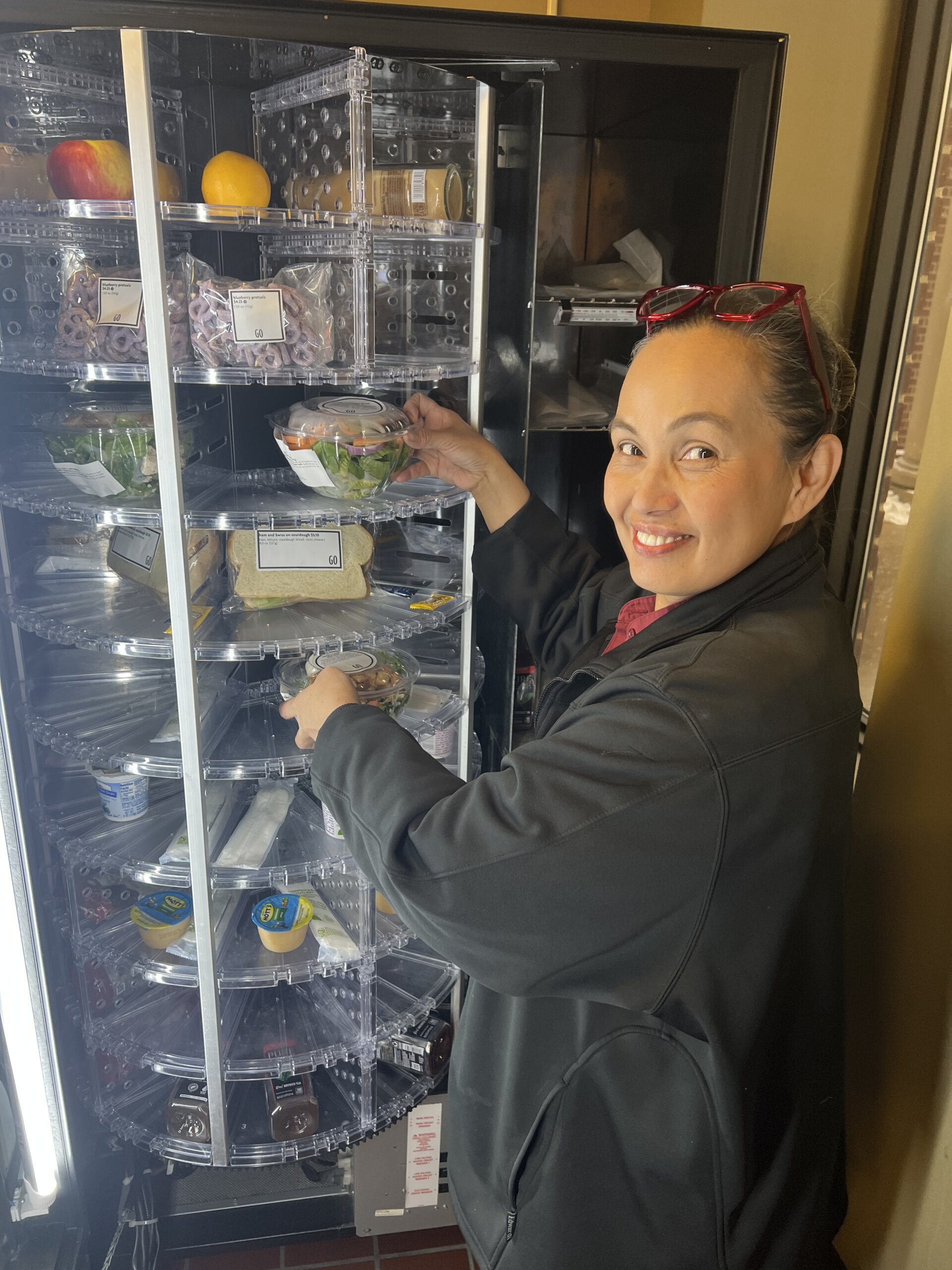 An employee of Bon Appetit stocks a freh food vending machine