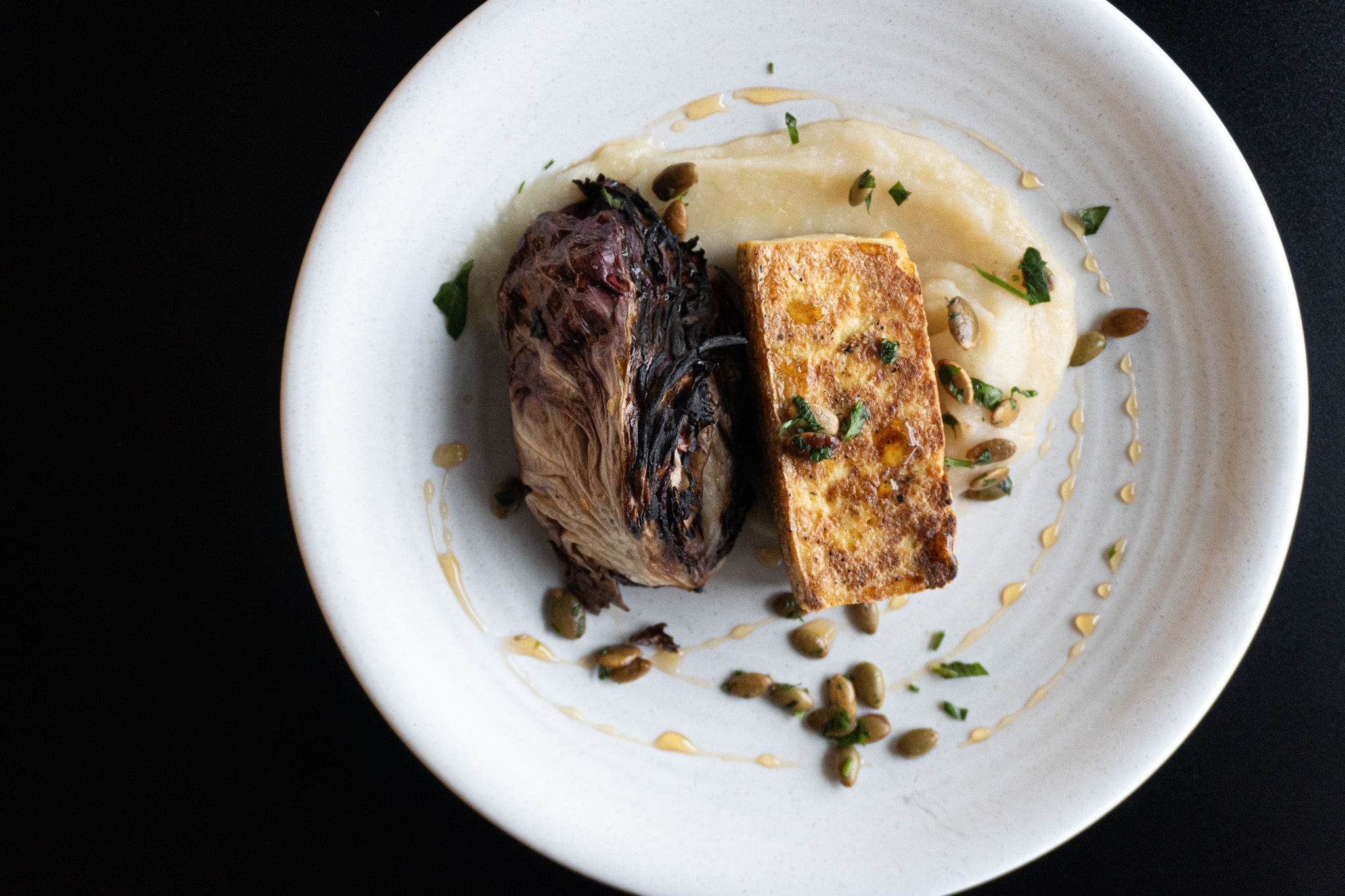 Overhead shot of a plant-forward dish, tea-smoked tofu and radicchio